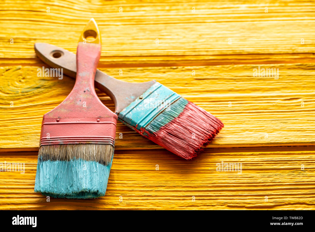 Coral color and yellow vivid grunge brushes on aged painted wood Stock Photo