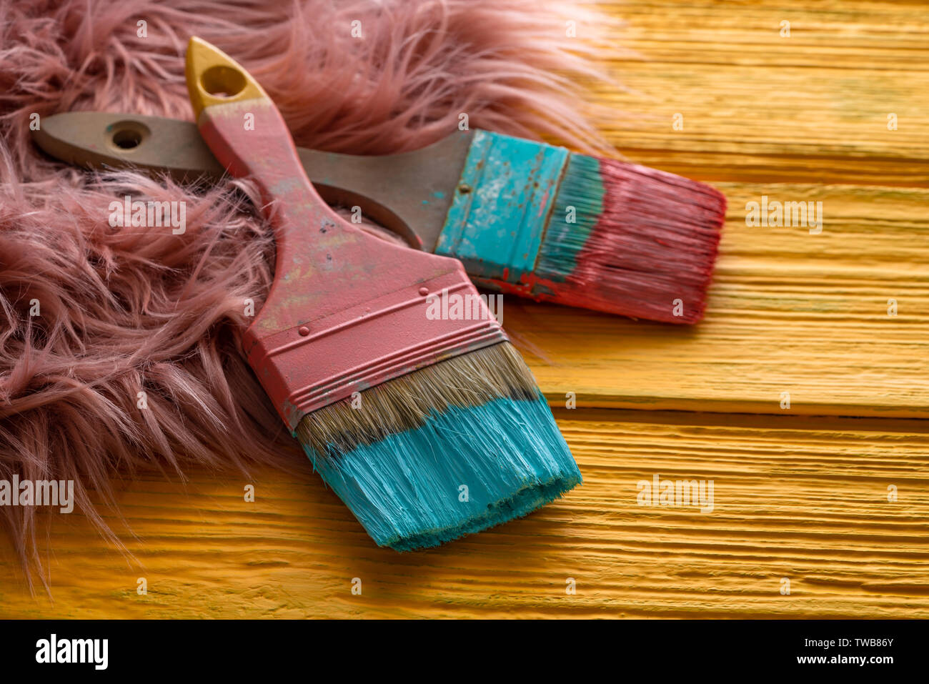 Coral color and yellow vivid grunge brushes on aged painted wood and fur Stock Photo
