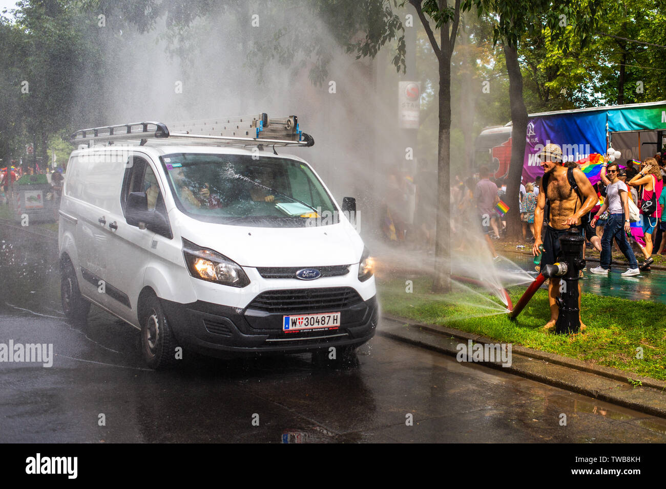 A white van passes a spraying jet of water at Euro Pride, the largest Pride event in Europe. Vienna 15 June 2019 Stock Photo
