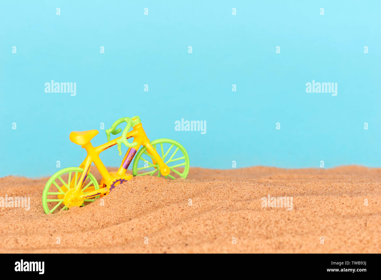 sandy beach by the sea. The concept of summer holidays and tourism. Toy bike on the beach. minimalism Stock Photo
