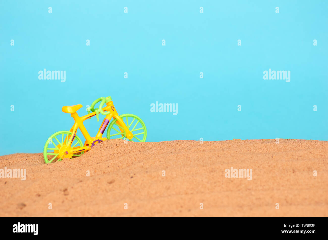 sandy beach by the sea. The concept of summer holidays and tourism. Toy bike on the beach. minimalism Stock Photo