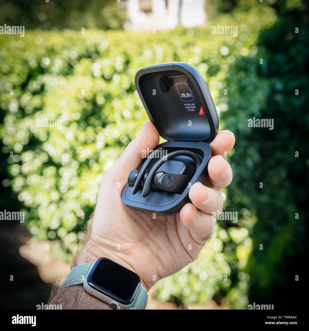 Paris, France - Jun 17, 2019: Lateral view of Powerbeats Pro Beats by Dr Dre wireless high-performance earphones charging case after unboxing man hand holding new music device - logotype insignia Stock Photo