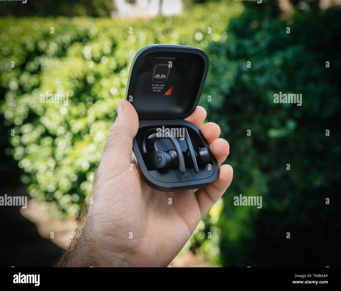 Paris, France - Jun 17, 2019: Side view of Powerbeats Pro Beats by Dr Dre wireless high-performance earphones charging case after unboxing man hand holding admiring the new music device Stock Photo