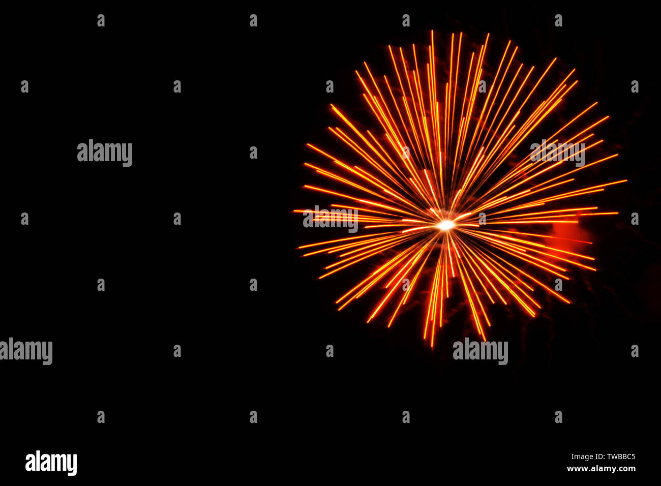 Orange fireworks explode in the sky during a fireworks show on long