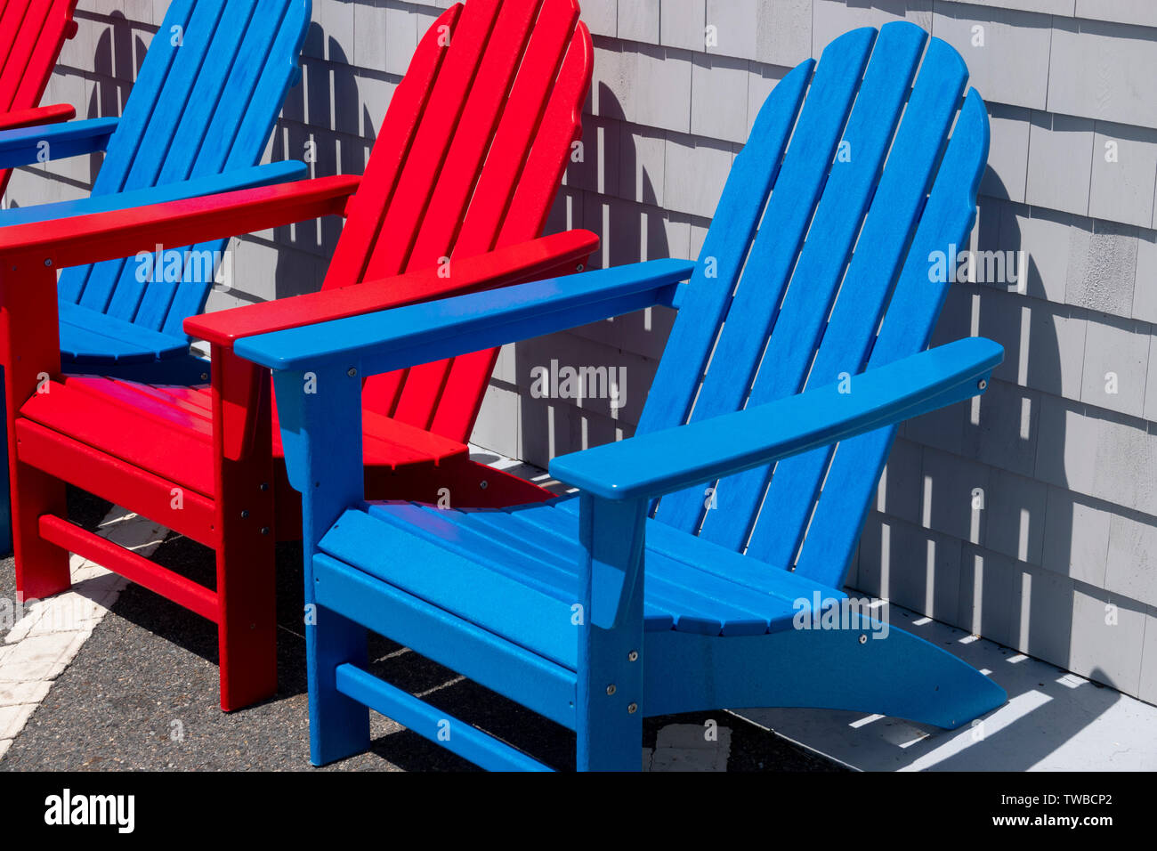 USA, Massachusetts MA Colorful red and blue Adirondack chairs made from recycled plastic Stock Photo