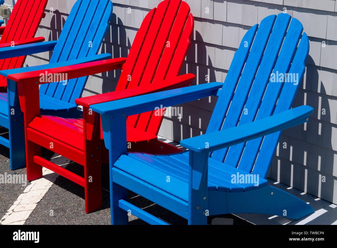 USA, Massachusetts MA Colorful red and blue Adirondack chairs made from recycled plastic Stock Photo