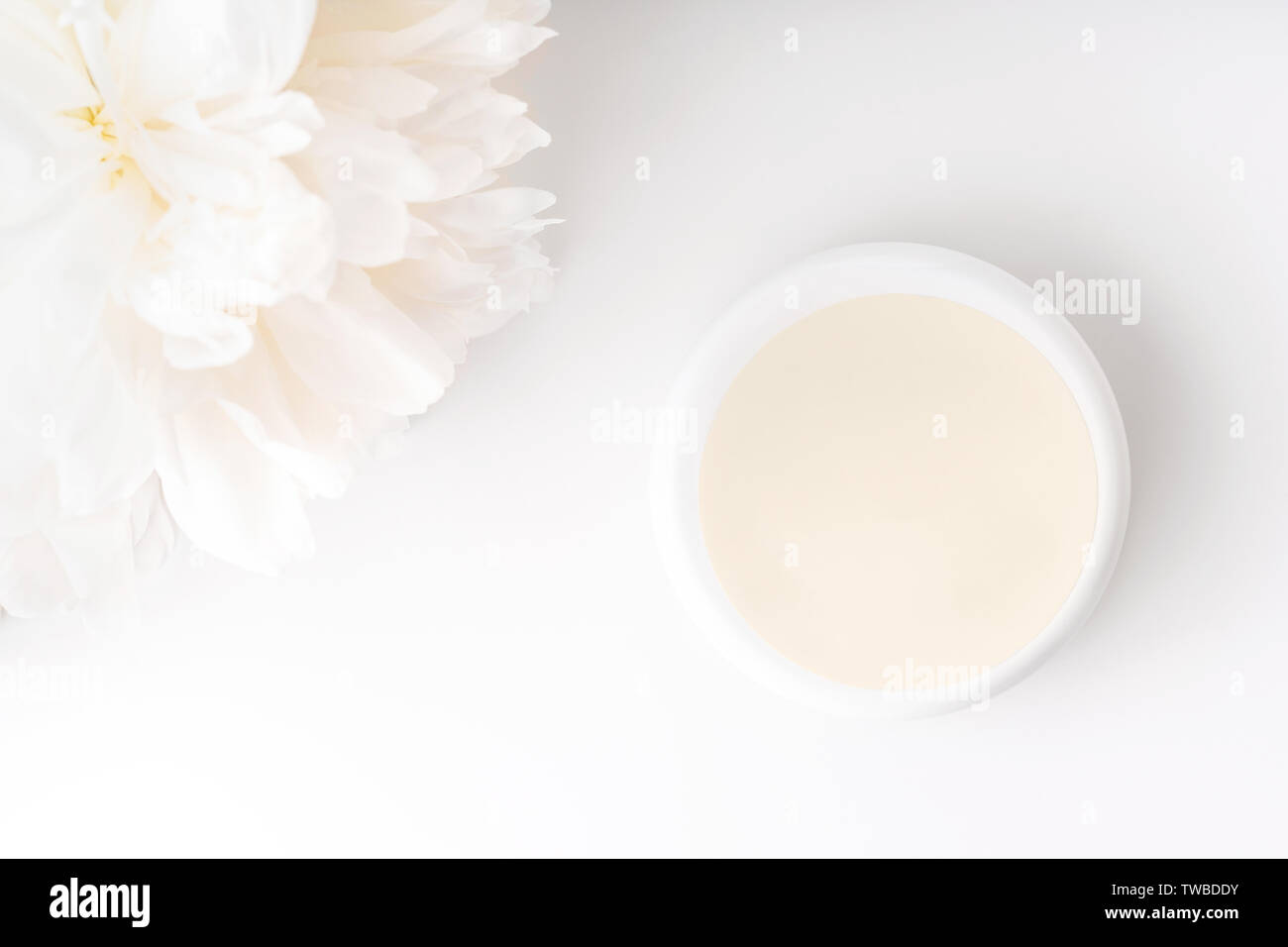 White peony and mockup face and body cream on white background. Cosmetics concept. Flat lay. Stock Photo