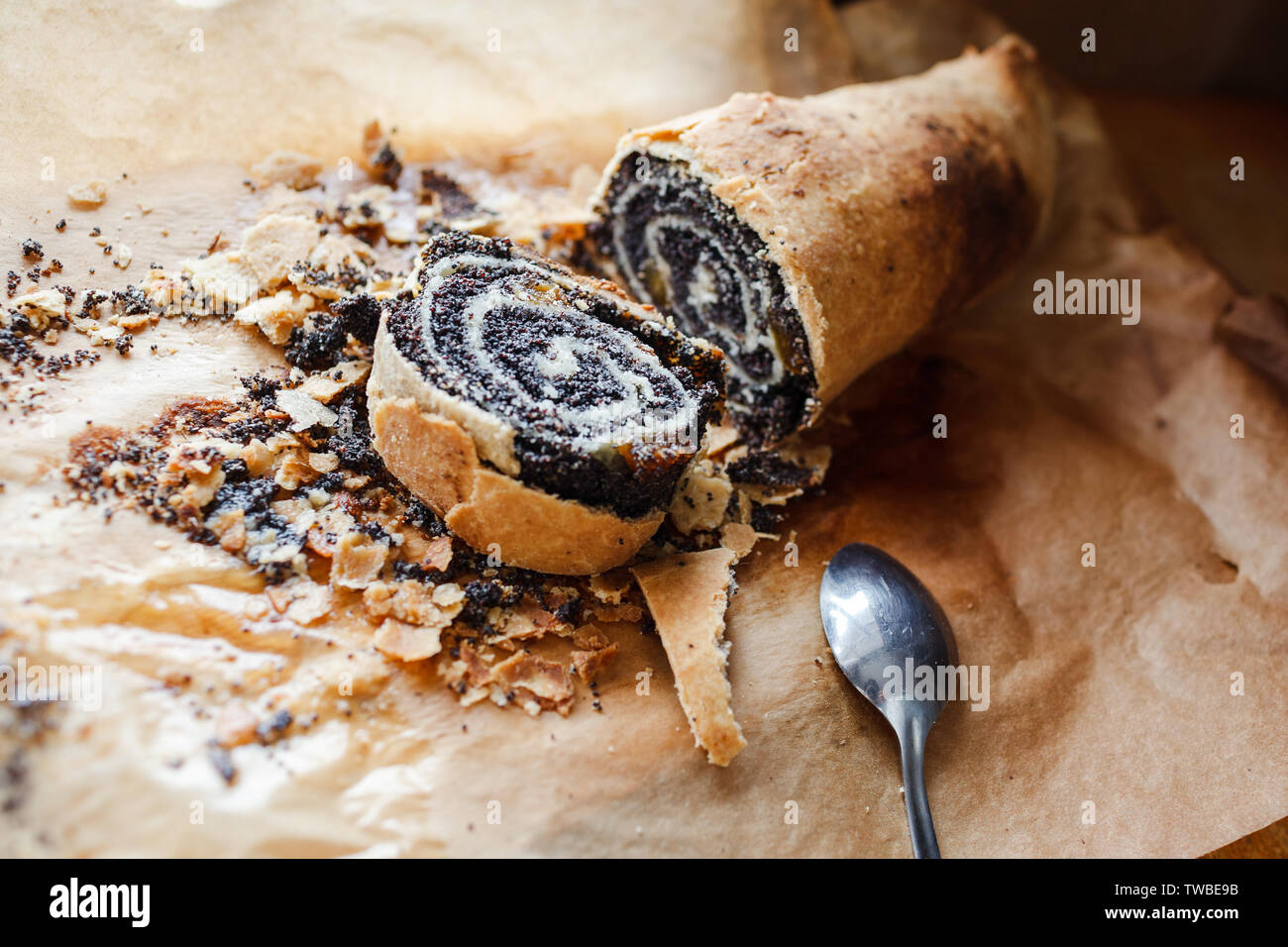 roll with poppy seeds on baking paper Stock Photo