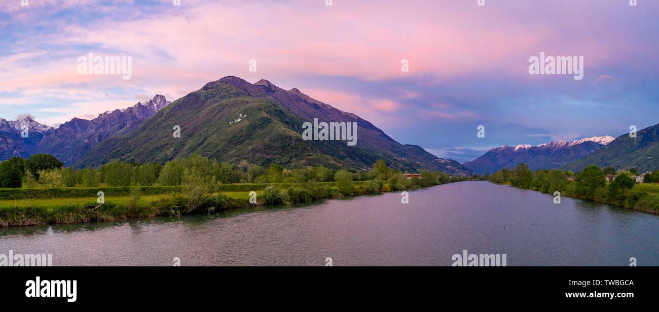 Aerial panoramic of sunset over river Adda and Rhaetian Alps, Sondrio province, Lower Valtellina, Lombardy, Italy Stock Photo