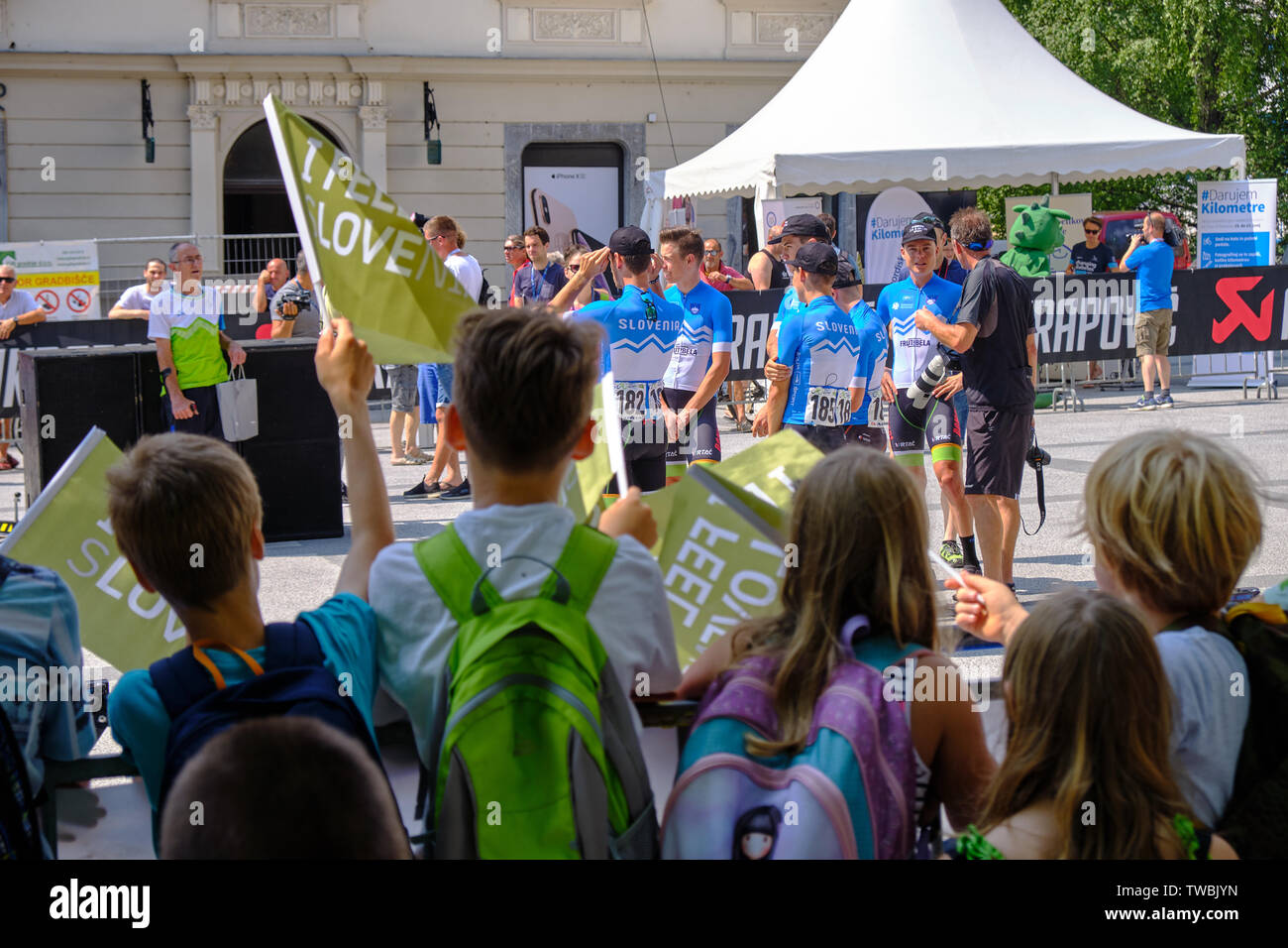 Children waving Flag as Team Slovenia is introduced at departure of Tour of Slovenia stage one race, Ljubljana, Slovenia - June 19, 2019 Stock Photo