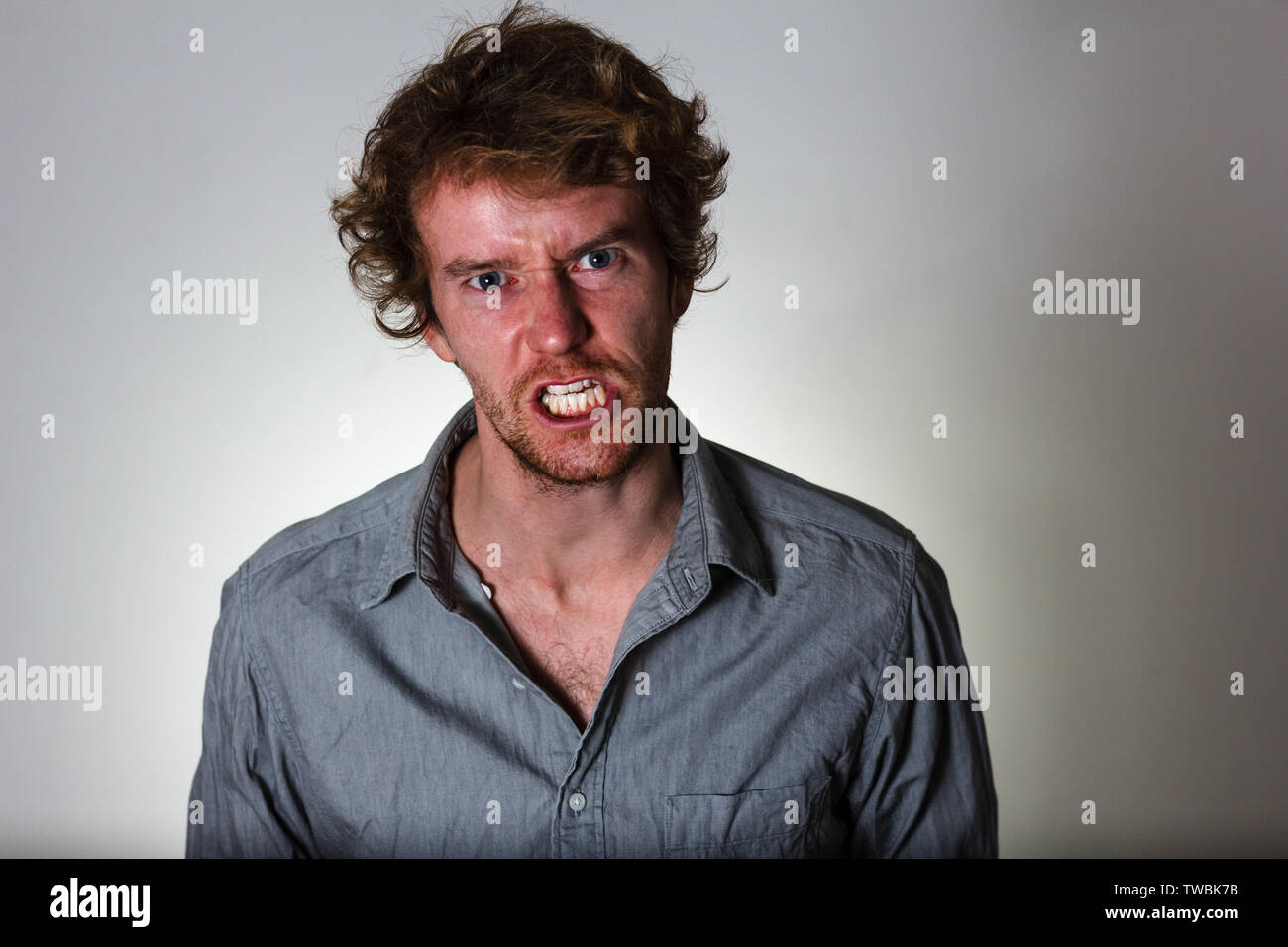 Angry young man on gray background Stock Photo