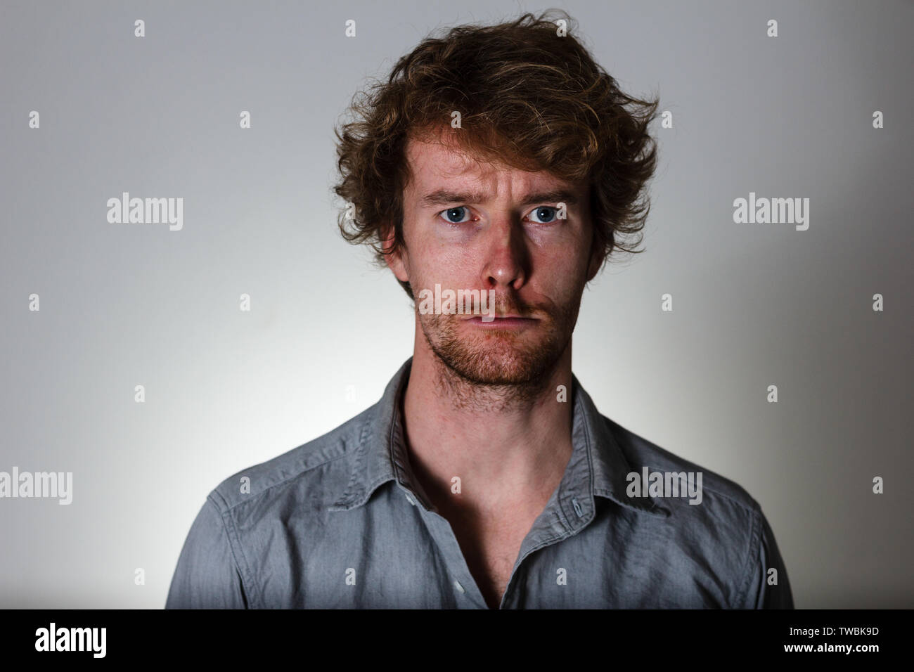 Weird expression young man on gray background Stock Photo