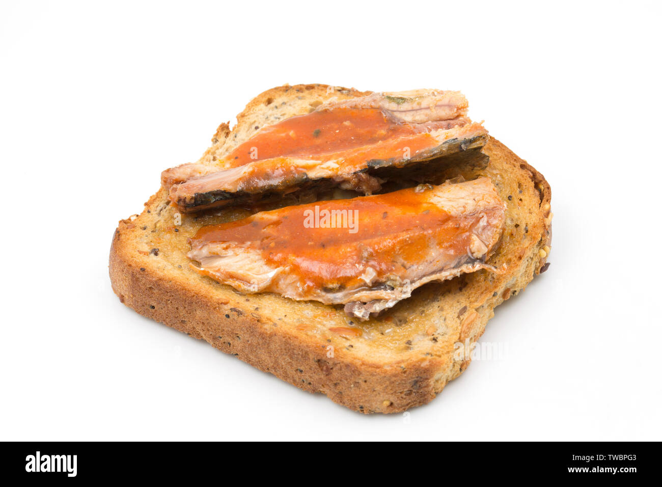 Tinned Asda Smart Price sardines in tomato sauce, caught in the central eastern Atlantic and served on toast. Photographed on a white background. Engl Stock Photo