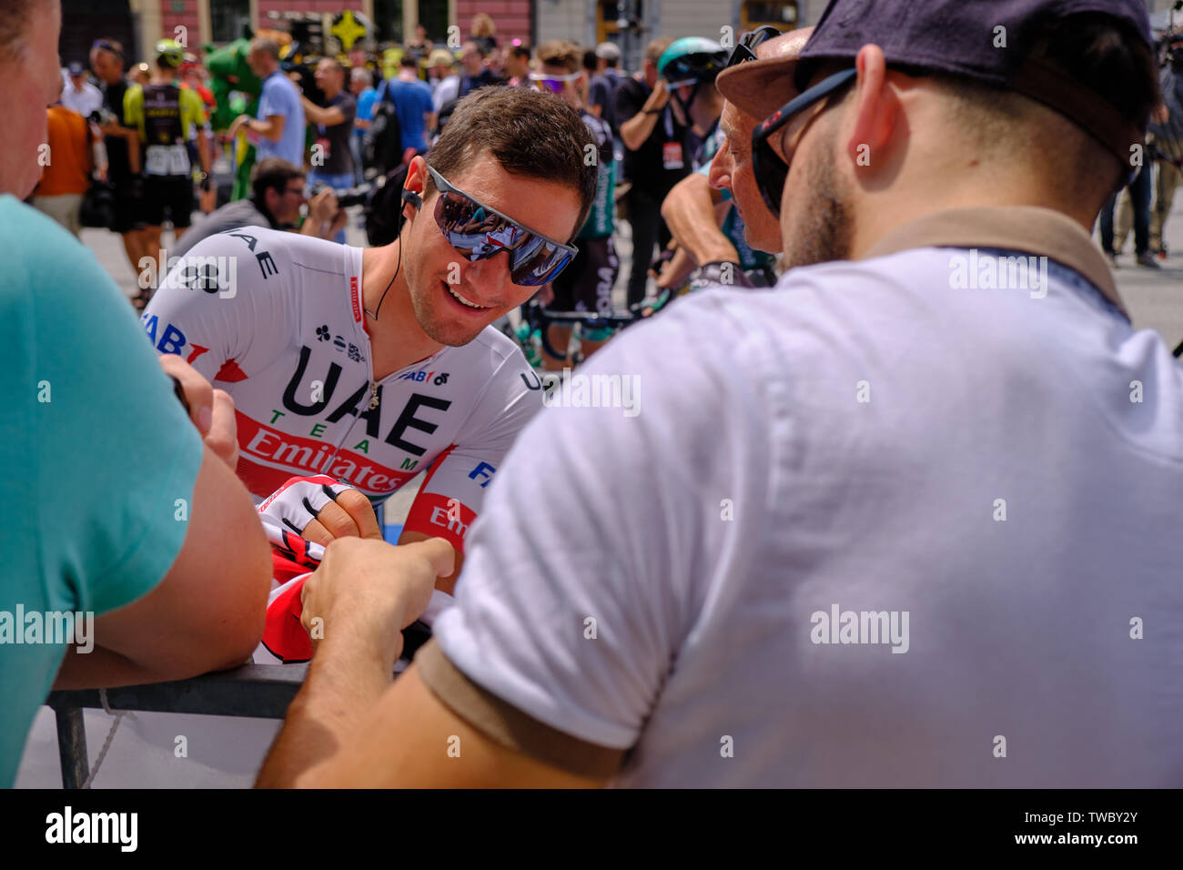 Jan Polanc of Team UAE Emirates signing jersey of local fan at departure of Tour of Slovenia stage one race, Ljubljana, Slovenia - June 19, 2019 Stock Photo