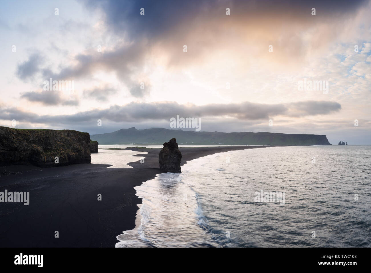 View from cape Dyrholaey on stack Arnardrangur and Reynisdrangar basalt sea stacks. Black volcanic sand on the ocean coast. Tourist attraction in the Stock Photo