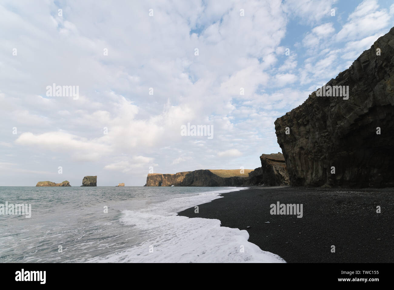 Tourist attraction in the south of Iceland near the village of Vik. Kirkjufjara beach near cape Dyrholaey. View of the famous arch. The beach with bla Stock Photo