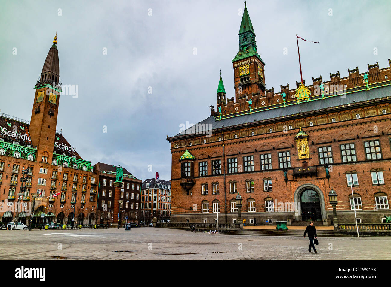A businessman walks past Copenhagen City Hall and the Scandic Palace Hotel on Radhuspladsen, or City Hall Square. Copenhagen, Denmark. January 2019. Stock Photo
