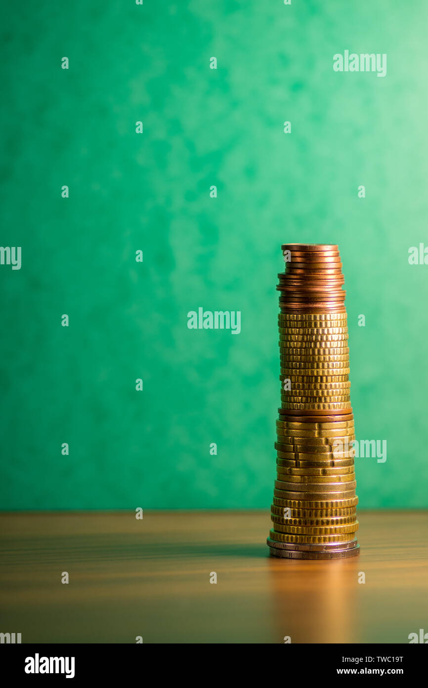 Stack of euro coins in a green background Stock Photo - Alamy