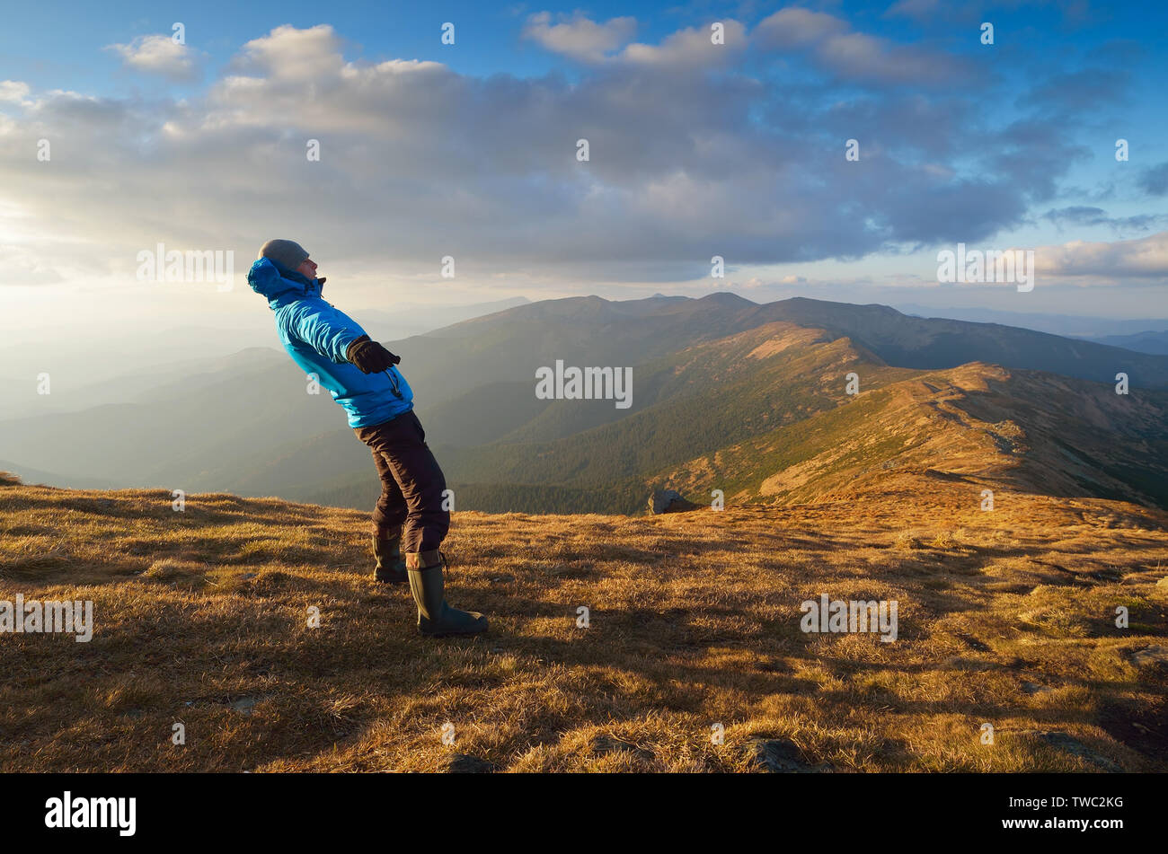 Man balances. Strong wind in the mountains. Autumn Landscape Stock Photo