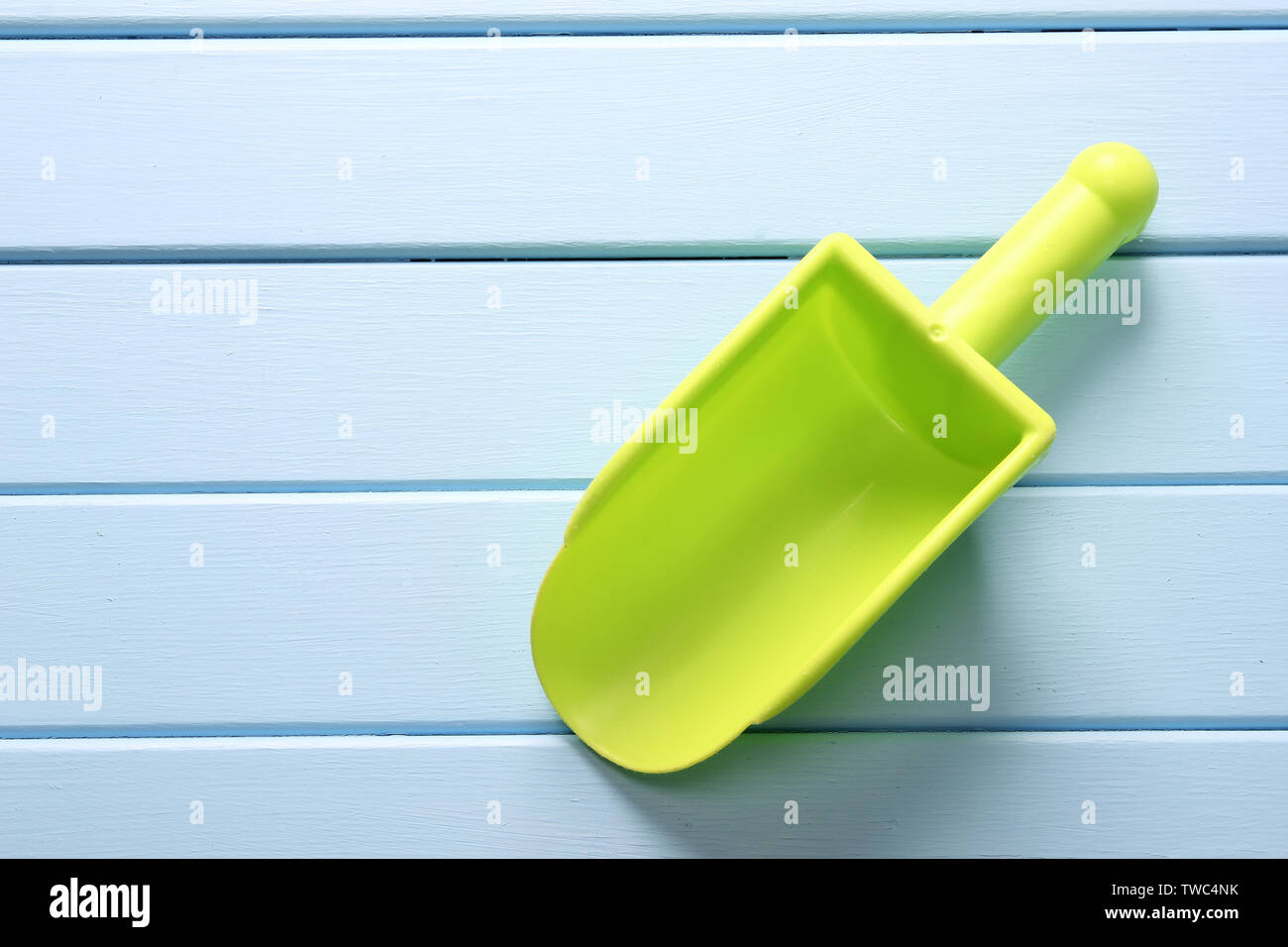 Green Plastic Scoop on Wooden Background Stock Photo