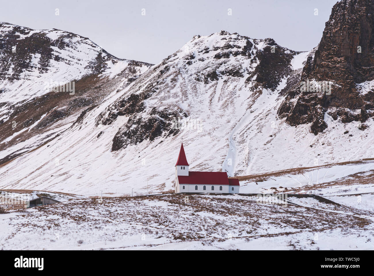 Little church situated on top of a hill, offering picturesque views of the ocean and the village of Vik. Stock Photo
