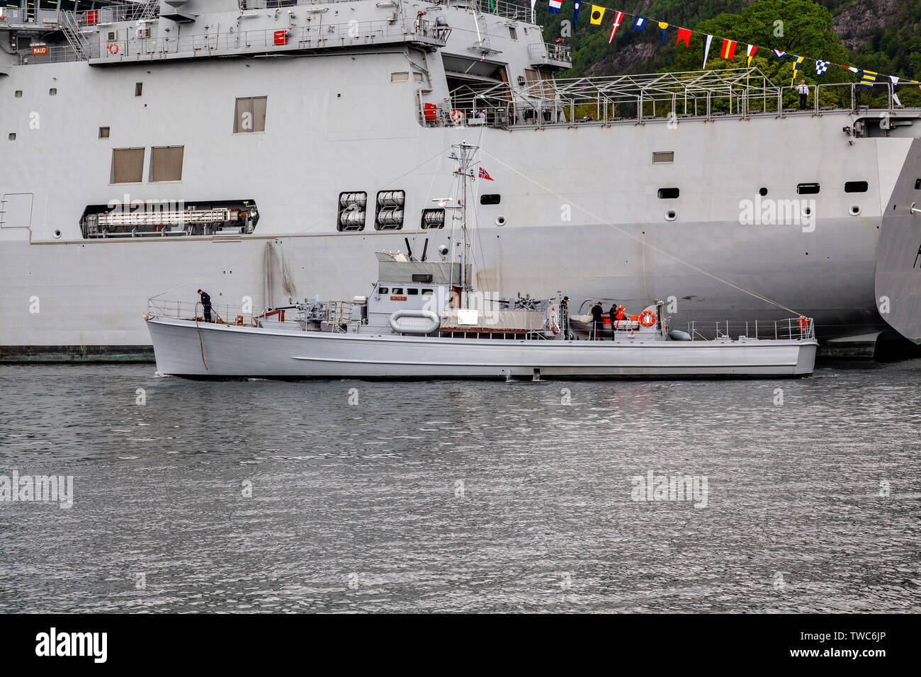Veteran submarine chaser Hitra (built 1942) passing in front of navy replenishment vessel HNOMS Maud at Festningskaien quay, in the port of Bergen, No Stock Photo