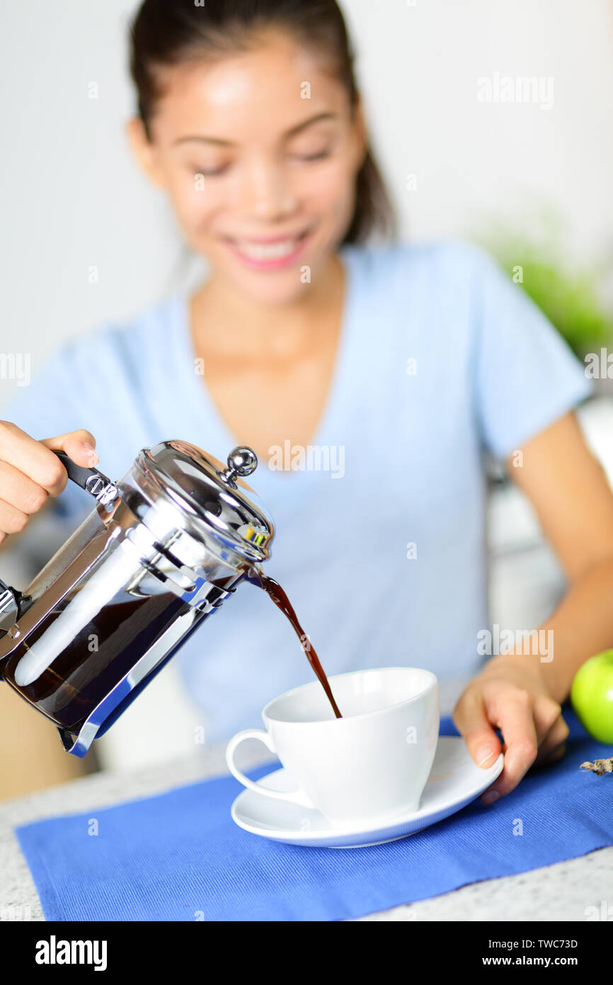 Coffee woman drinking french press coffee at breakfast table in the