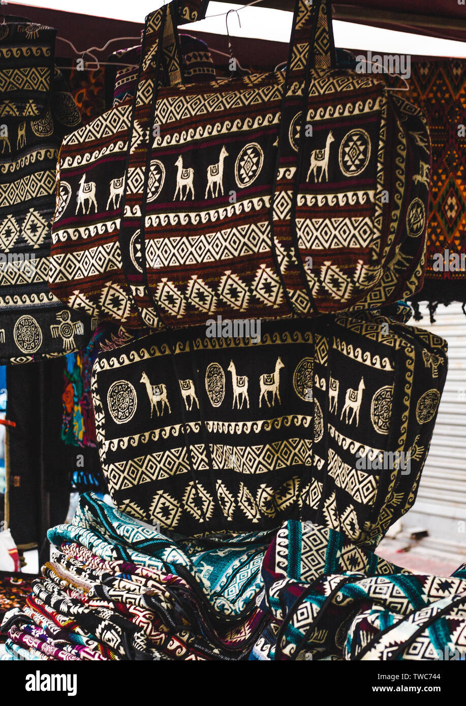 Street stall with woven fabric llama bag souvenirs in Otavalo, Ecuador, one of the biggest artisanal markets in South America Stock Photo