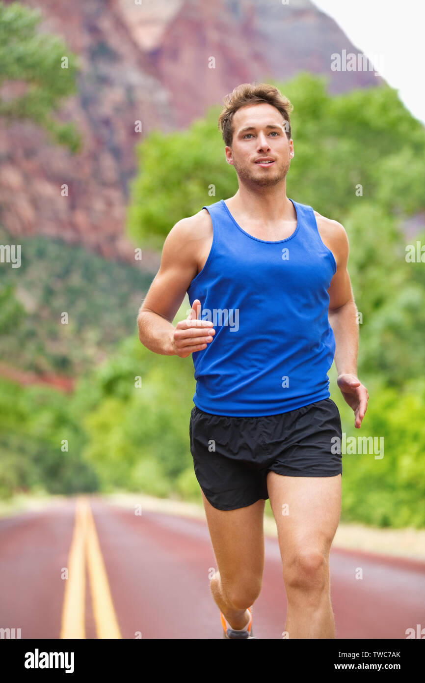 Athlete runner running on road. Fitness man jogging in workout wellness