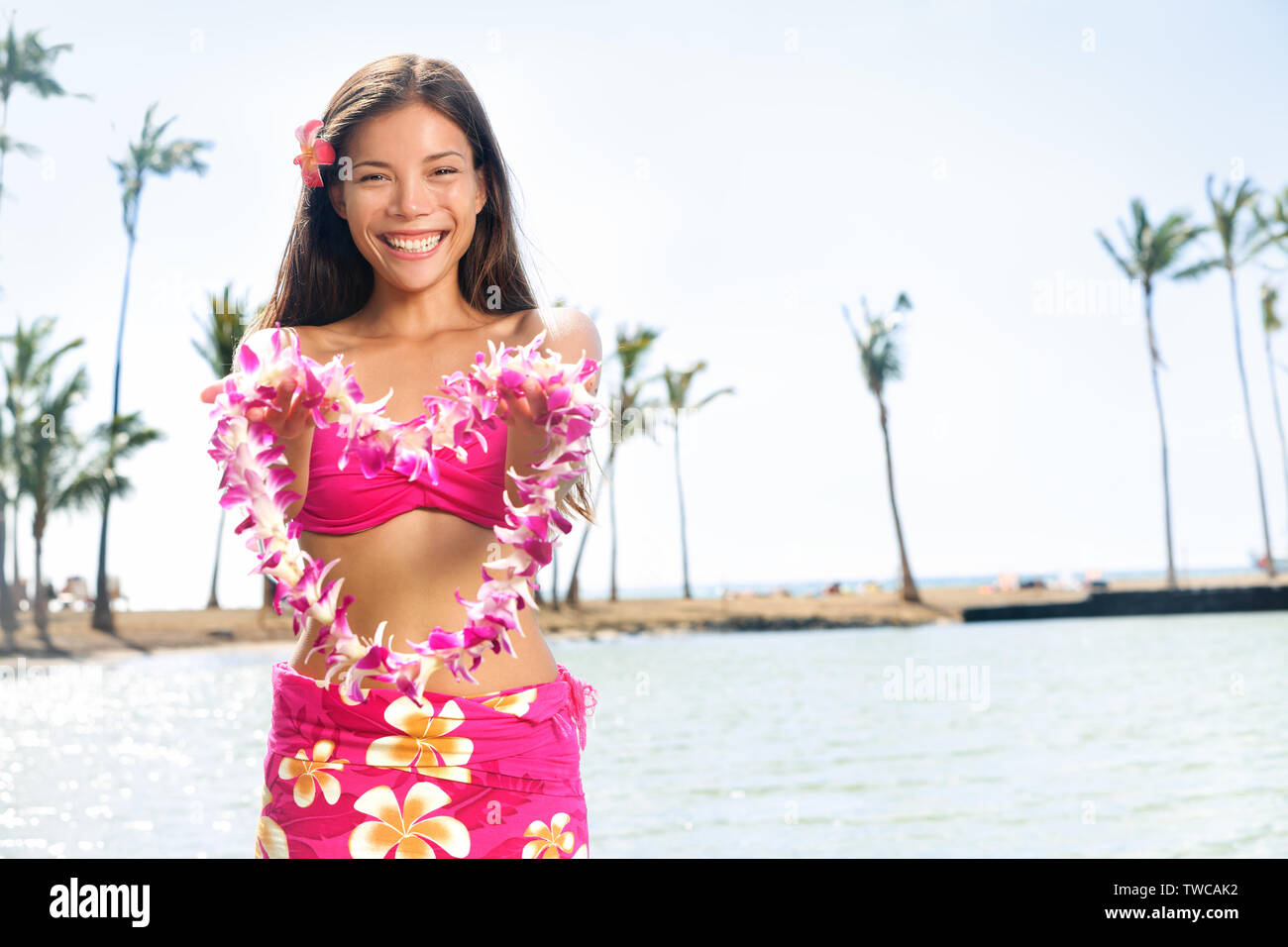 Hawaii woman showing flower lei garland of pink orchids. Beautiful