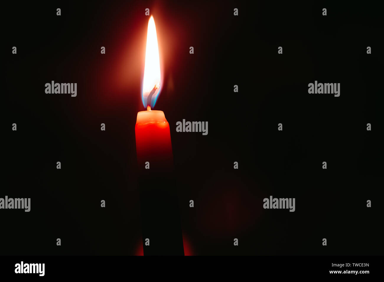 red candle burns in the dark Stock Photo Alamy