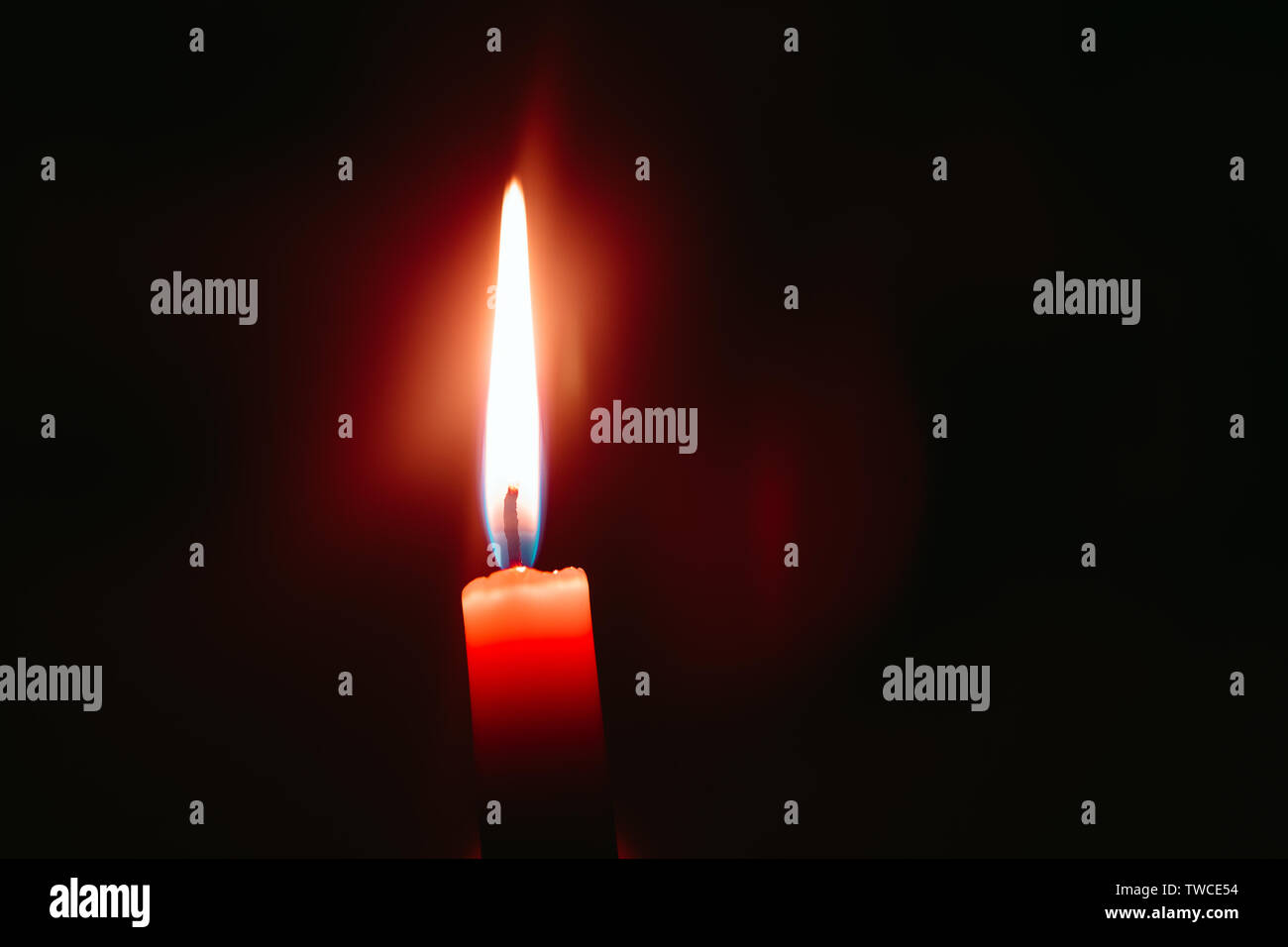red candle burns in the dark Stock Photo Alamy