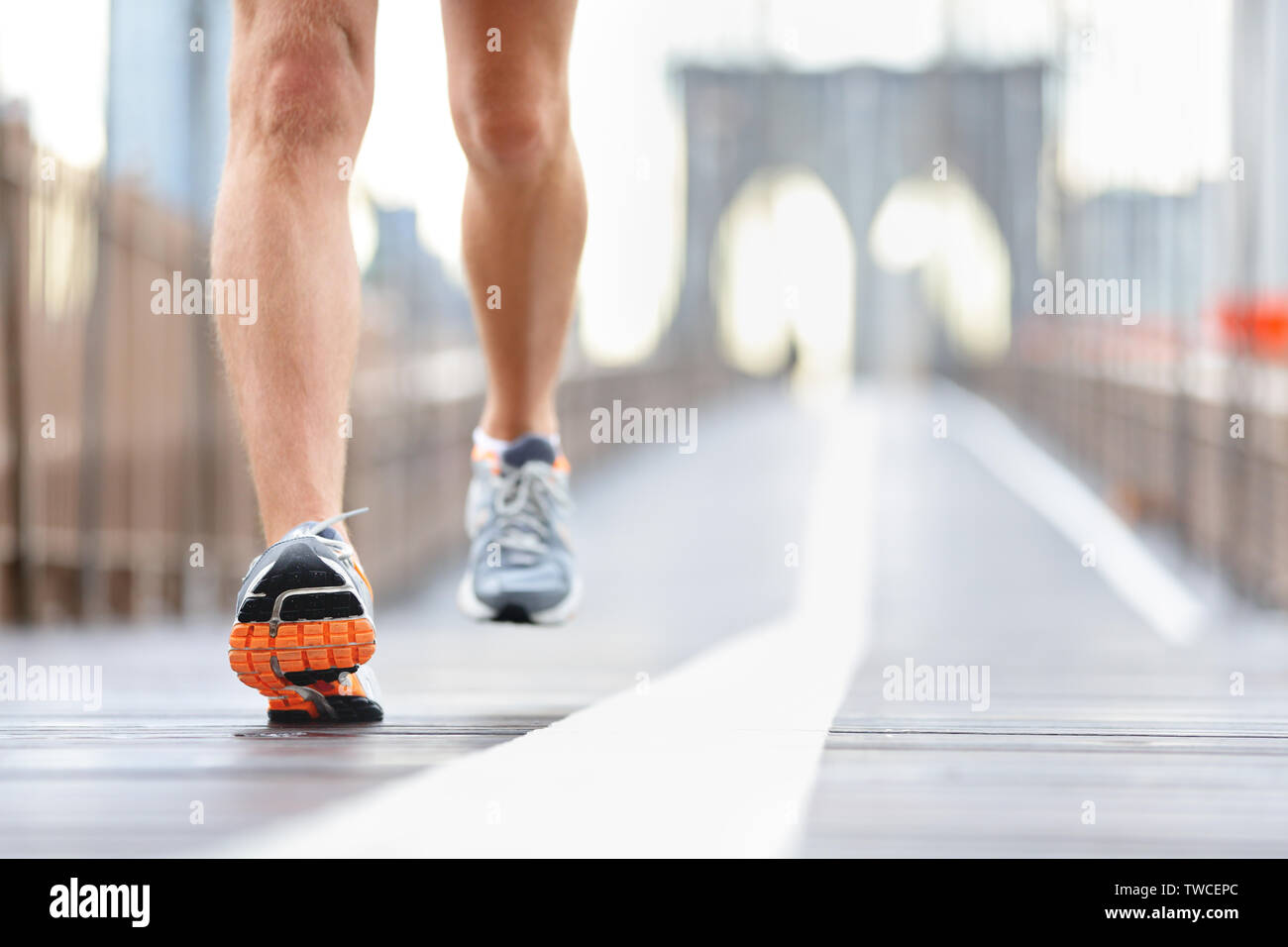 Running shoes, feet and legs close up of runner jogging in action and motion on Brooklyn Bridge, New York City, USA Stock Photo