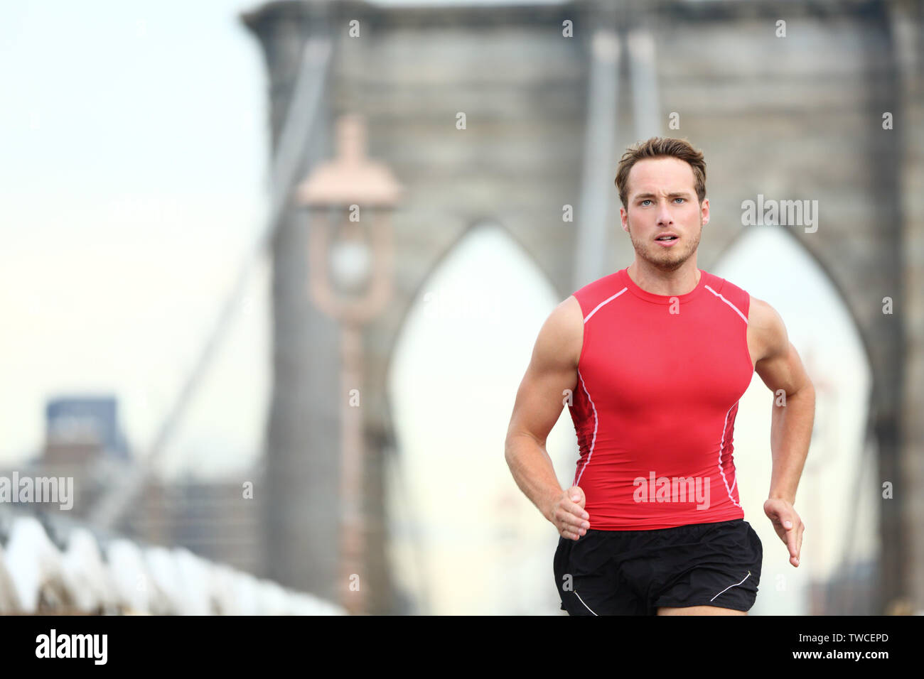 Running man sprinting in New York City. Runner on training run outside. Caucasian male runner and fitness sport model in sprint wearing compression clothing on Brooklyn Bridge, New York City, USA. Stock Photo