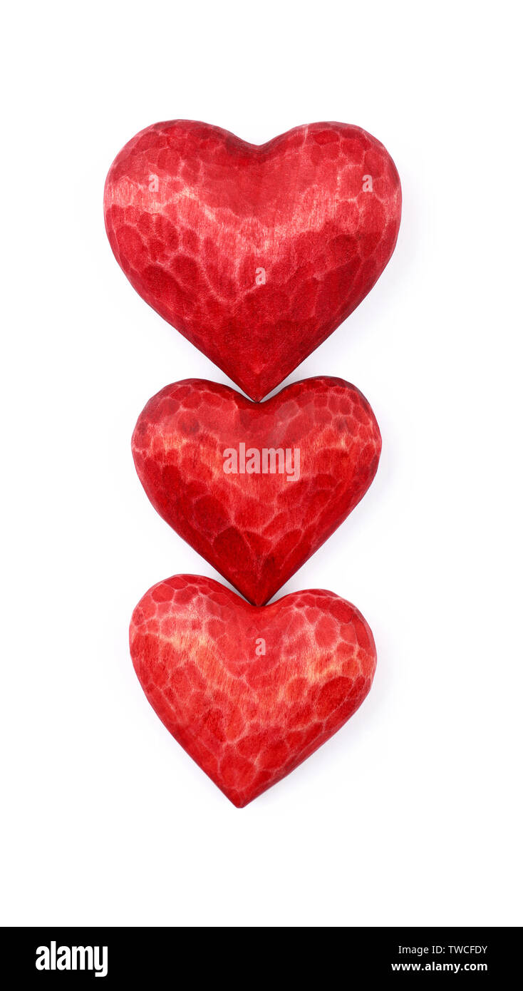 Close up three red painted natural wooden carved hearts isolated on white background Stock Photo