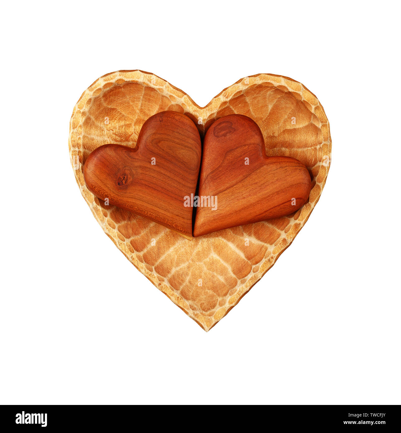 Close up two brown unpainted natural wooden carved hearts in heart shaped bowl isolated on white background Stock Photo