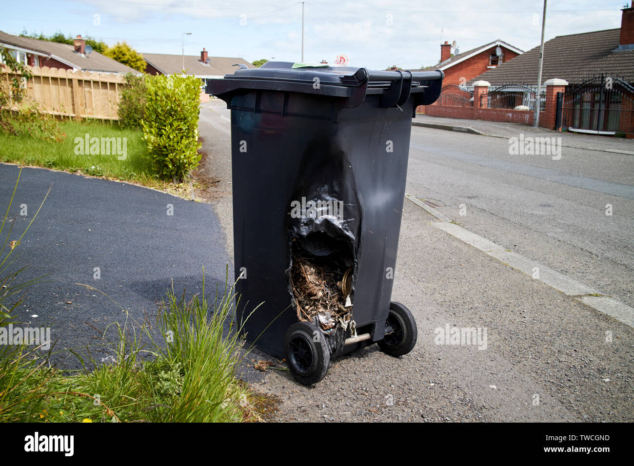 fire damaged wheelie bin left sitting on a uk street Stock Photo