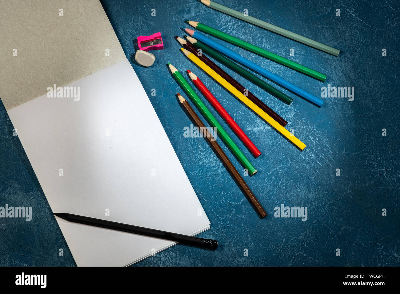 drawing pad and colored pencils on blue background Stock Photo Alamy