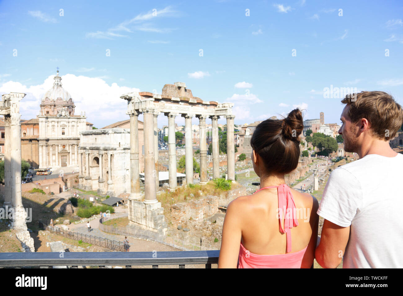 Roman Forum tourists looking at landmark in Rome sightseeing on travel vacation in Rome, Italy. Happy tourist couple, man and woman traveling on holidays in Europe smiling happy. Stock Photo