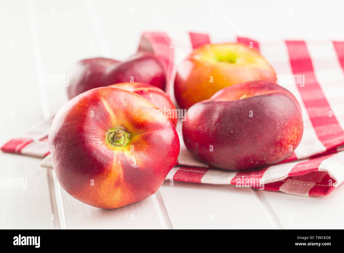 Ripe flat nectarines on white table. Stock Photo