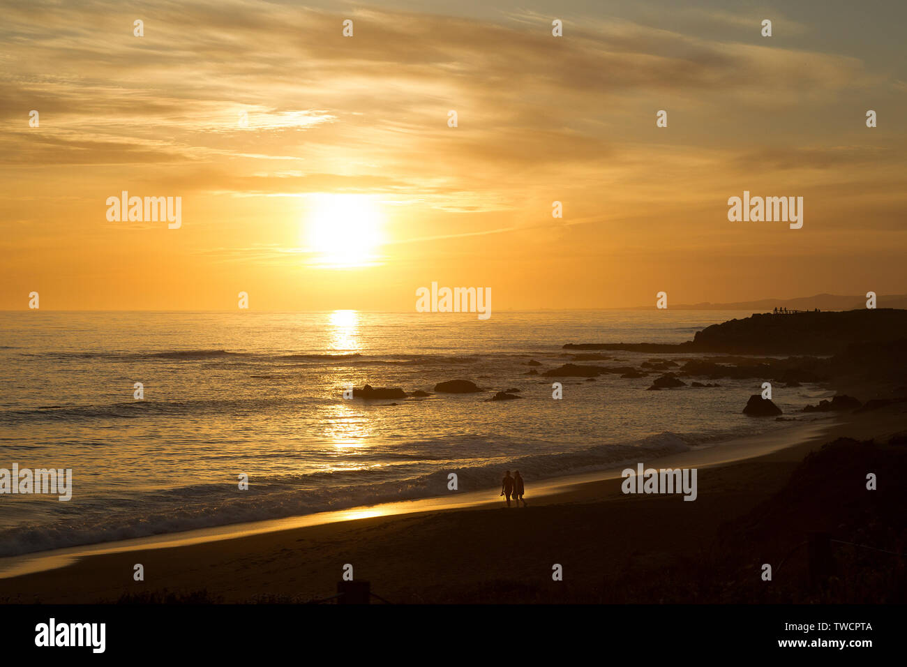 Couple walking hand in hand along beach at sunset hi-res stock ...