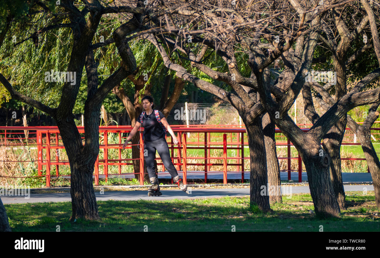 Temperley, Buenos Aires, Argentina. June 19, 2019. A young woman with rollers and headphones listens to music while skating in a public park. Stock Photo