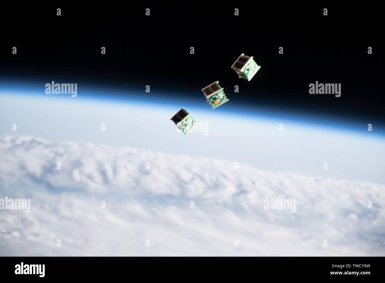 A set of tiny satellite sfrom Singapore, also known as a CubeSat, is ejected from the Japanese Small Satellite Orbital Deployer on the International Space Station June 17, 2019 in Earth Orbit. Stock Photo