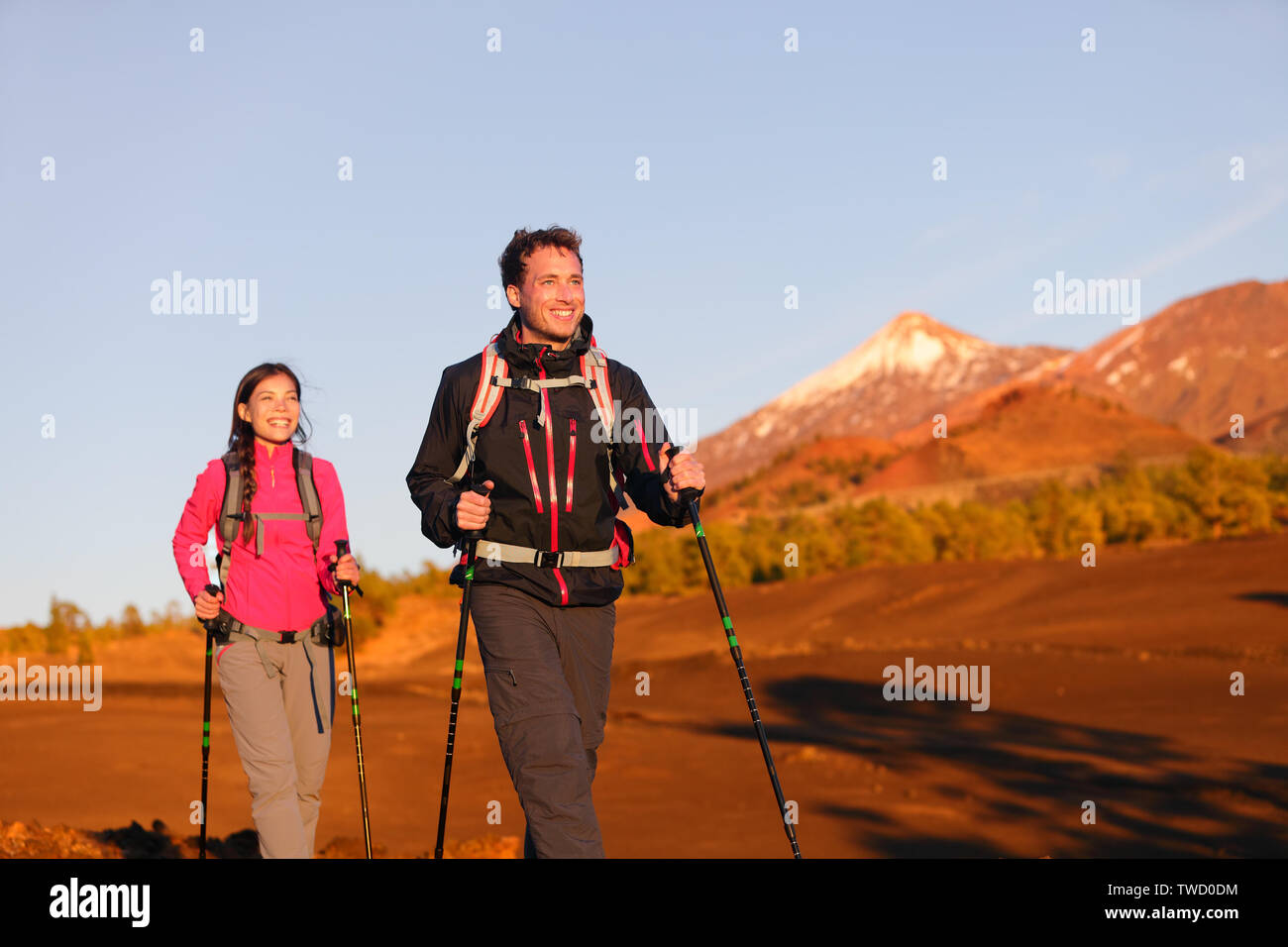 Hikers people hiking - healthy active lifestyle. Hiker couple hiking in beautiful mountain nature landscape. Woman and man hikers walking during hike on volcano Teide, Tenerife, Canary Islands, Spain. Stock Photo