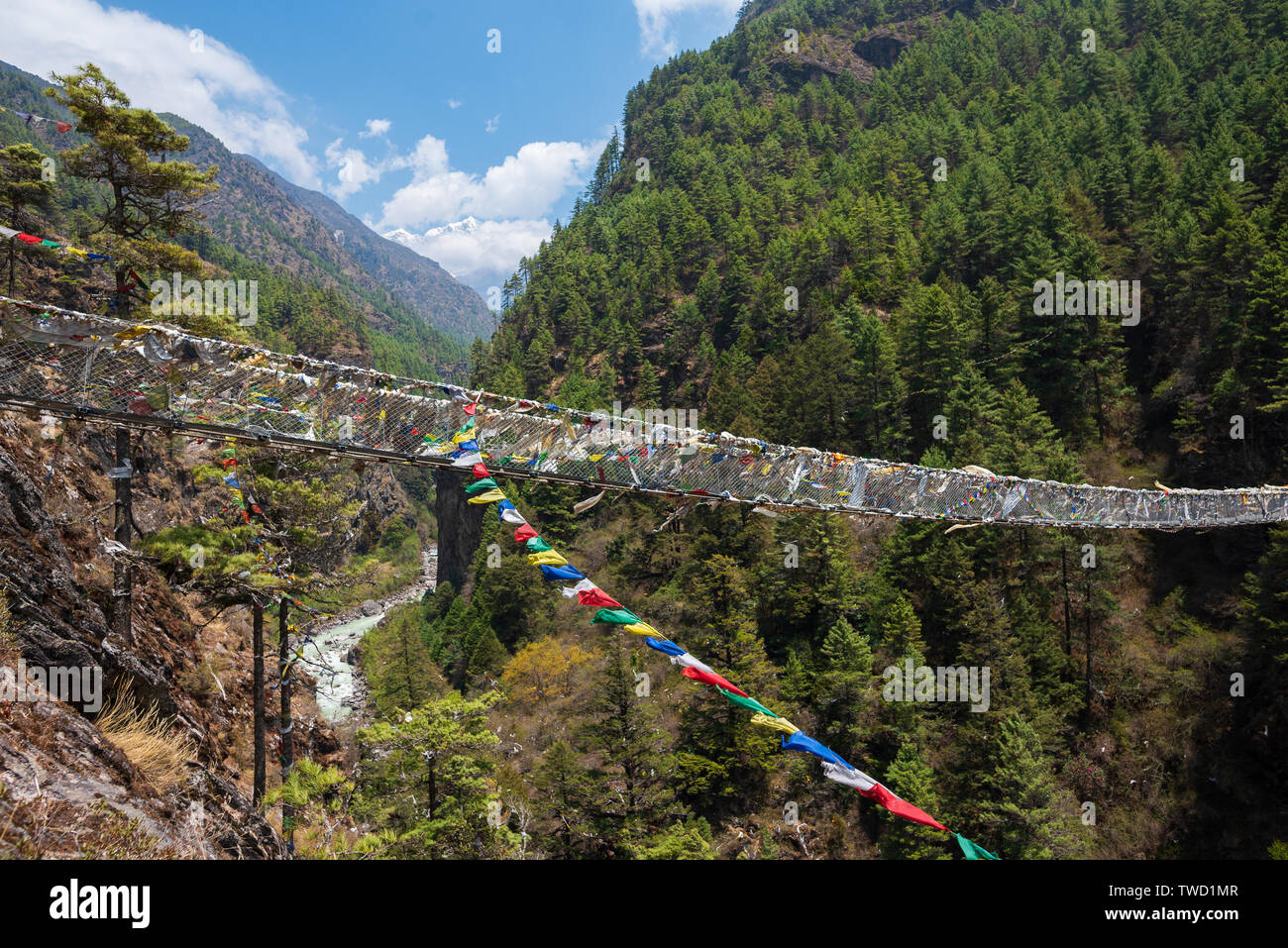 Hillary suspension bridge over small river in Himalayas in Nepal Stock Photo