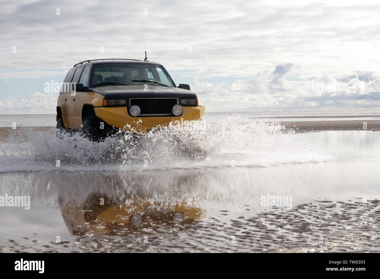 big off-road SUV car on sea shore background with water splashes closeup view Stock Photo