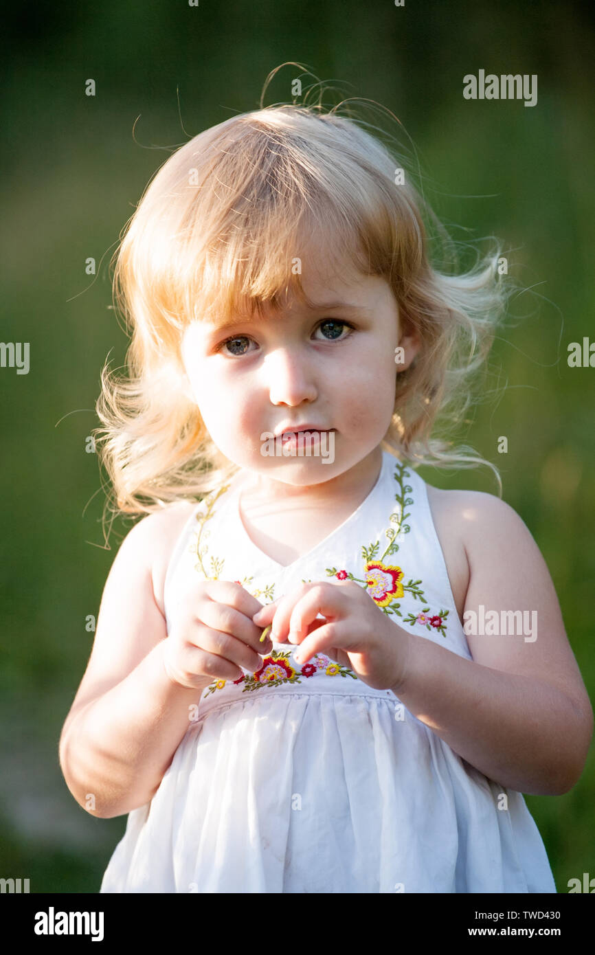 two years old caucasian girl in white dress closeup portrait Stock Photo