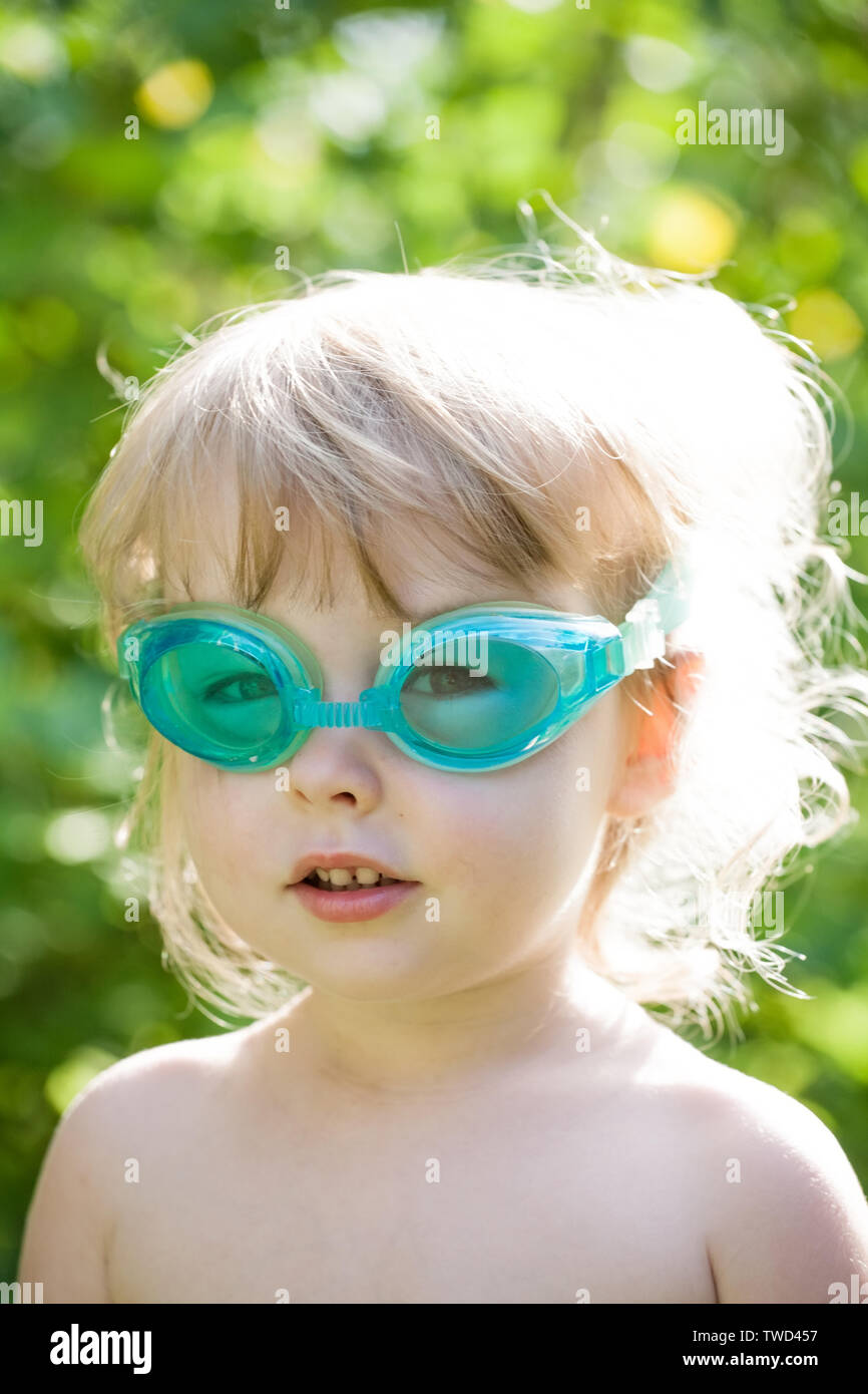 little toddler caucasian girl in swimming glasses face closeup Stock Photo