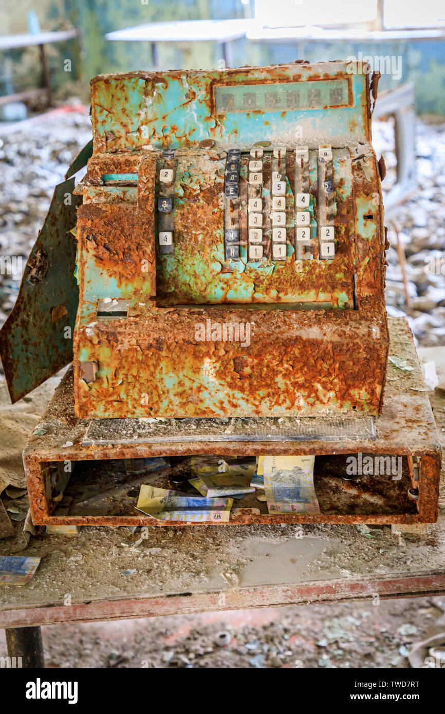 Eastern Europe, Ukraine, Pripyat, Chernobyl. Rusted cash register, book and money. Stock Photo