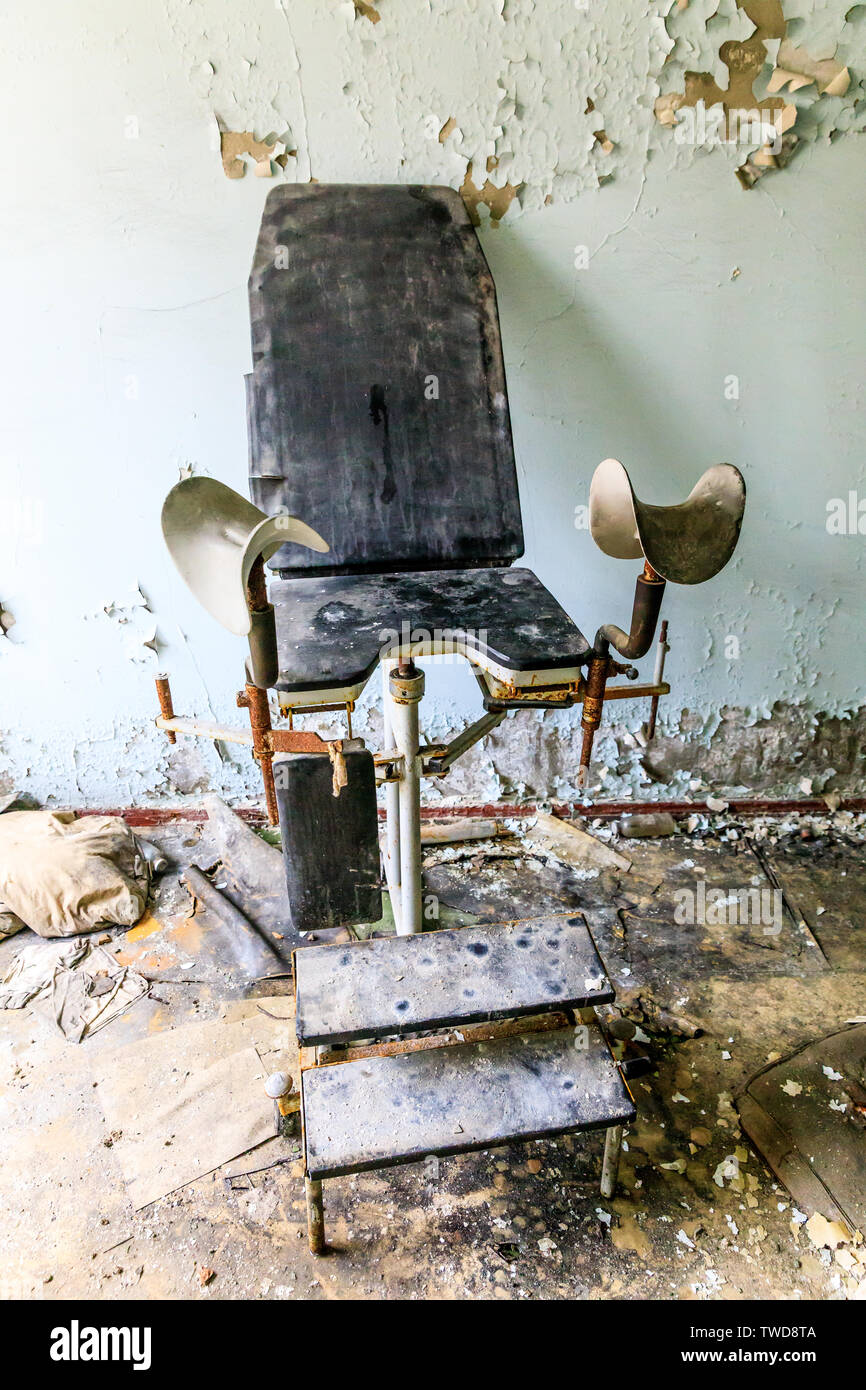 Eastern Europe, Ukraine, Pripyat, Chernobyl. The Hospital MsCh-126 (medical-sanitary unit). Chair with leg braces in delivery room. Stock Photo